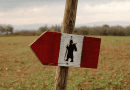 Tappa della Via Francigena San Giminiano - Monteriggioni. Nella foto è raffigurata la freccia bianca e rossa con dentro il pellegrinetto nero